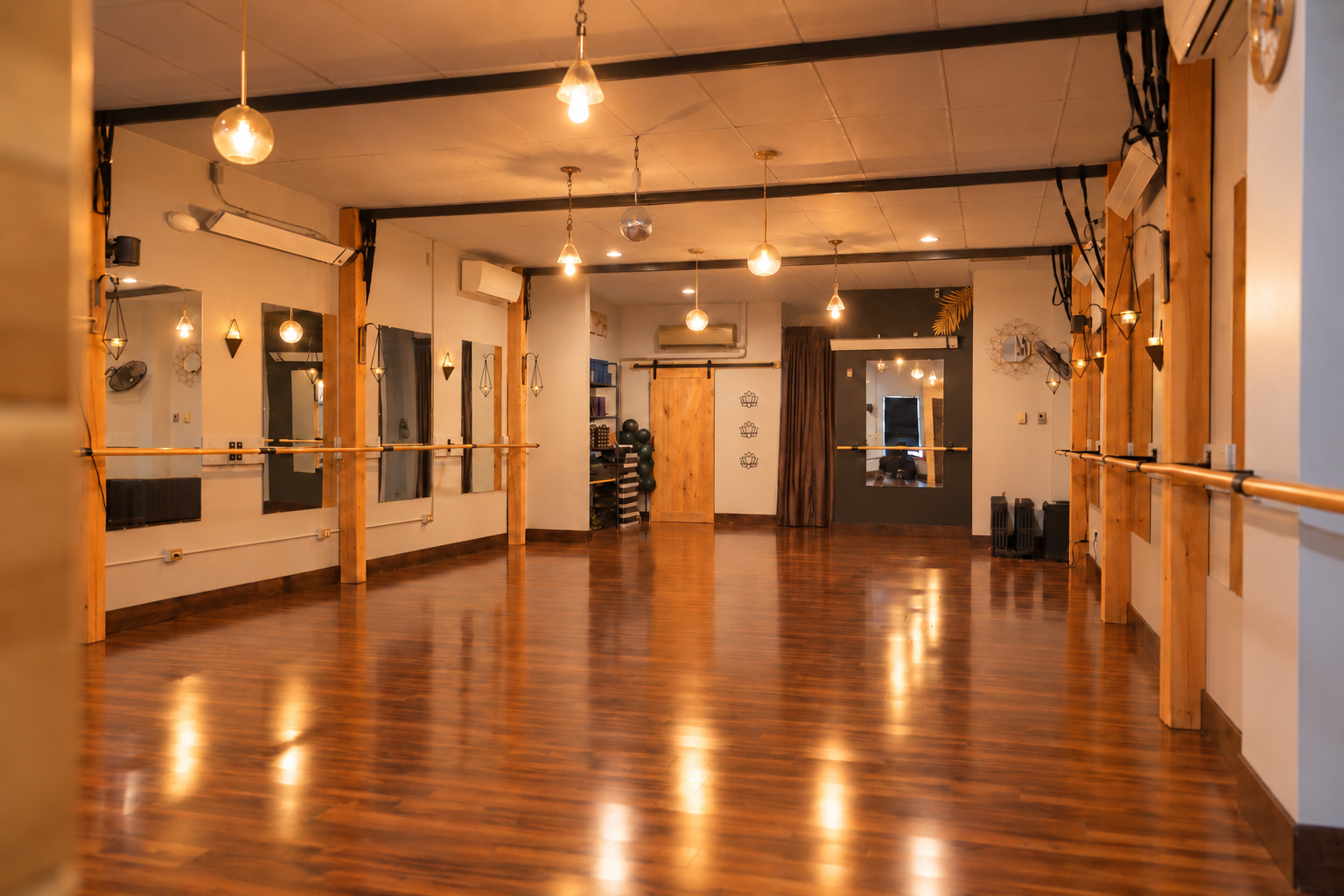 An updated view of Triumph Studio’s open room with wooden floors and warm lighting