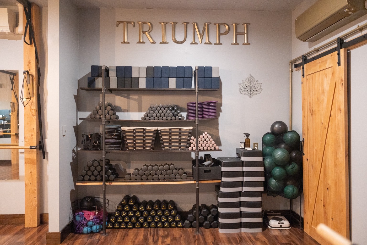 Organized mats, blocks, weights, and exercise equipment at Triumph Studio